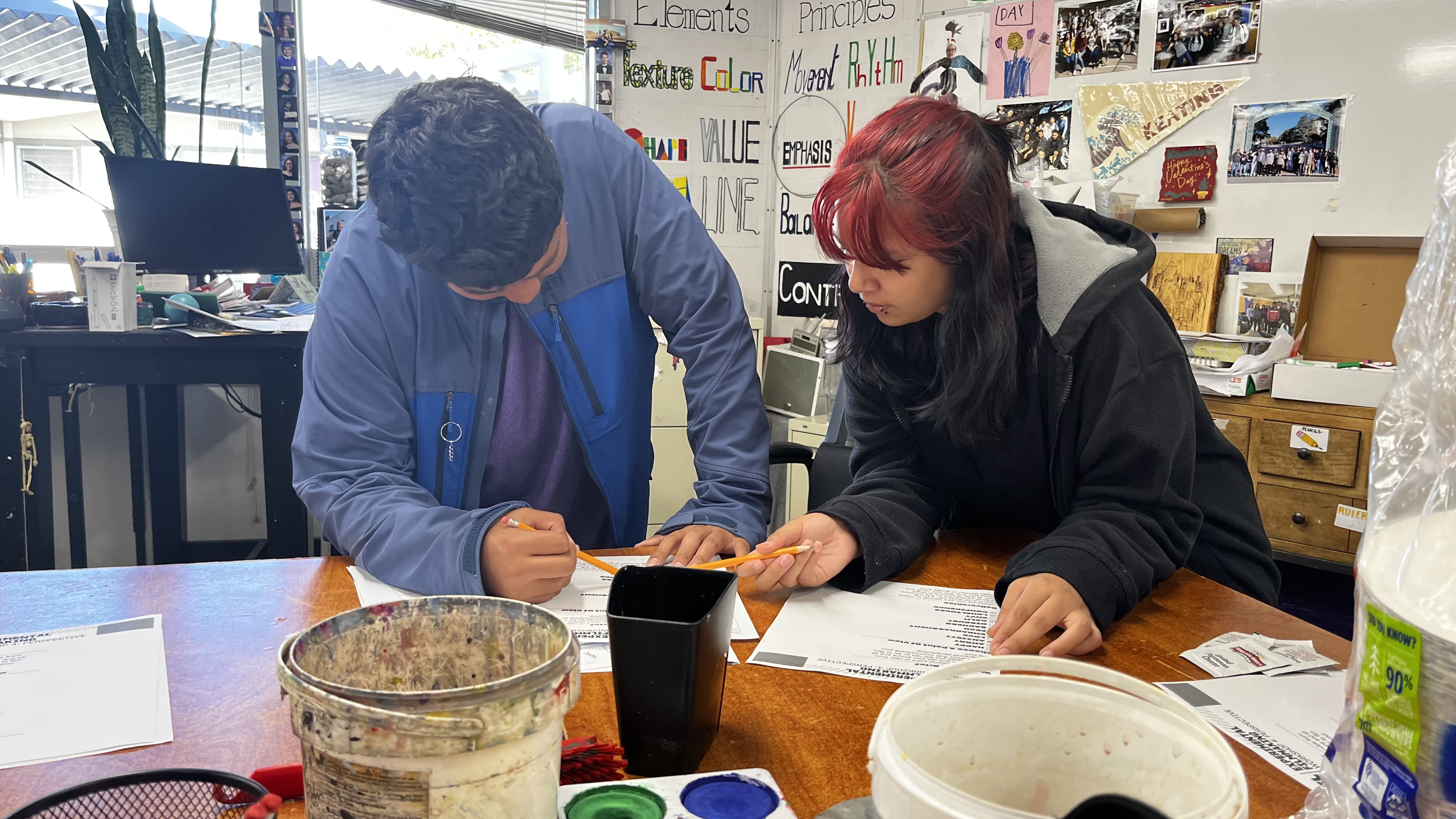 Two REEL students developing a screenplay together in the art classroom